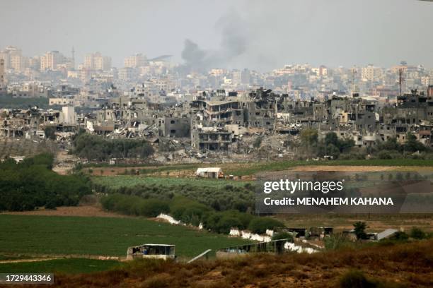 Graphic content / TOPSHOT - A picture taken from the southern Israeli city of Sderot on October 17 shows destroyed buildings in the northern Gaza...