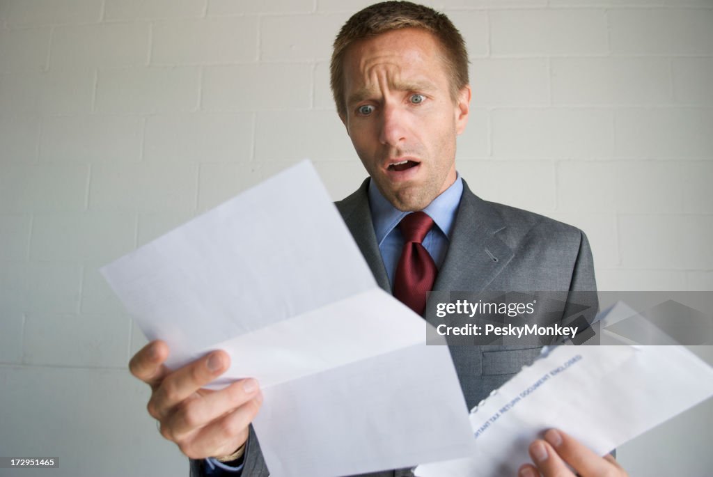 Businessman Opens Letter with Expression of Disbelief