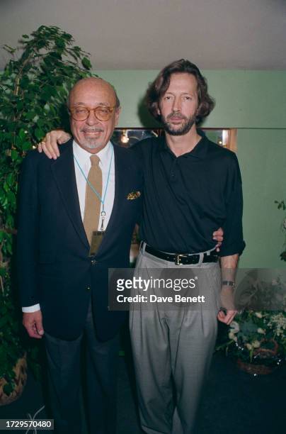 Turkish-American businessman Ahmet Ertegun and English guitarist Eric Clapton in London, circa 1990.