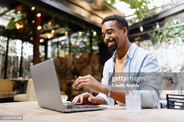 hombre moderno trabajando en una computadora portátil en la cafetería - usar el ordenador fotografías e imágenes de stock