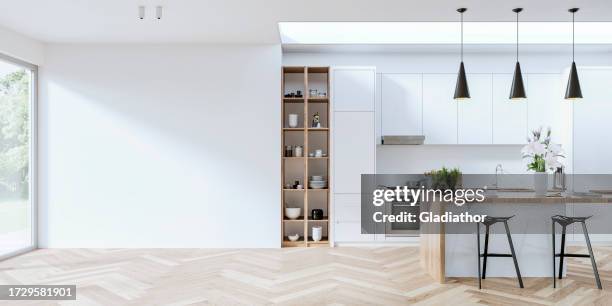 modern white kitchen with rectangular breakfast kitchen island with stools, empty large white wall in front of a window - indoors stock pictures, royalty-free photos & images