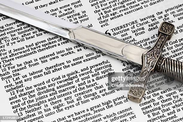 zwei zweischneidigen schwert entwickeln auf bibel offen für die buchung von hebrews - schwert stock-fotos und bilder