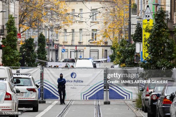 Police officer stands guard in the street in the Schaerbeek area of Brussels on October 17 where the suspected perpetrator of the attack in Brussels...