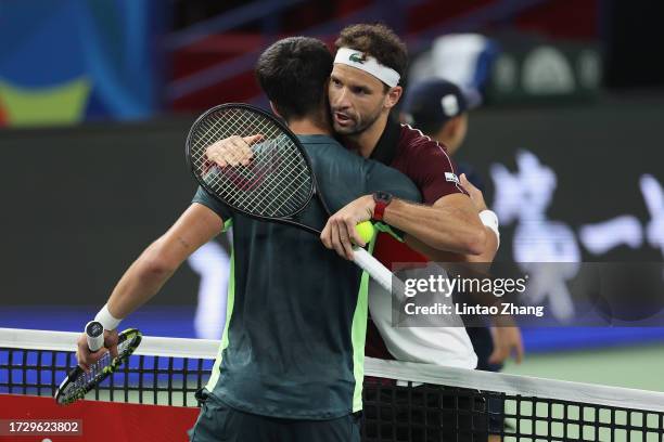 Grigor Dimitrov of Bulgaria shakes hands with Carlos Alcaraz of Spain after win the Men's Singles Round of 16 match against on Day 10 of the 2023...