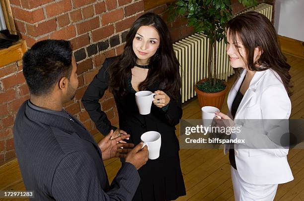 two women and a man drinking coffee and discussing ideas - story telling in the workplace stockfoto's en -beelden