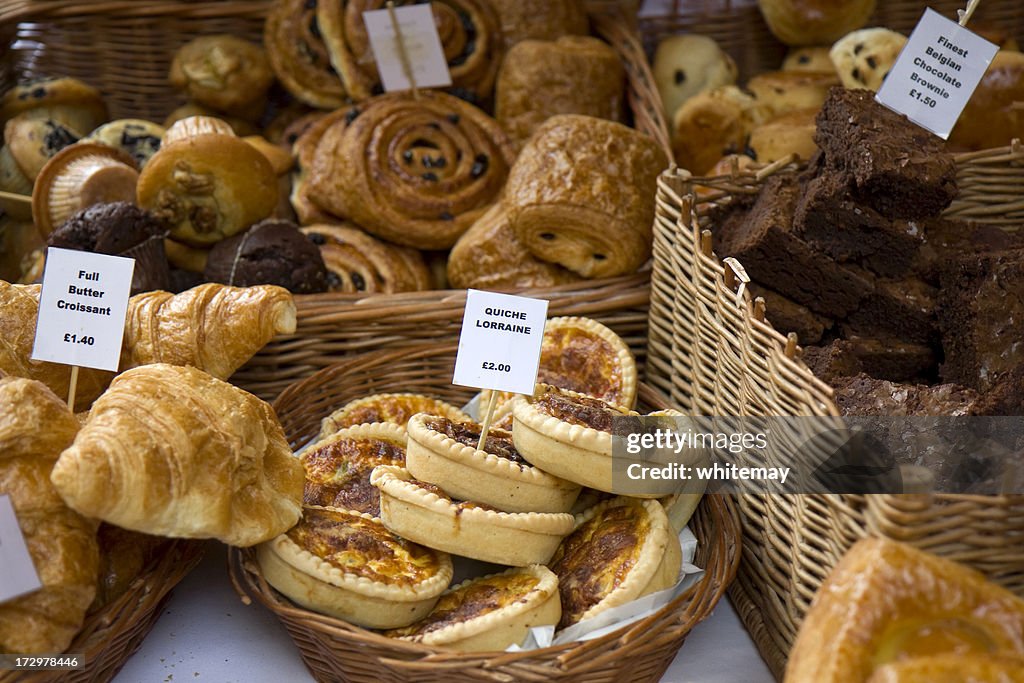 Assorted pastries for sale displayed in wicker baskets