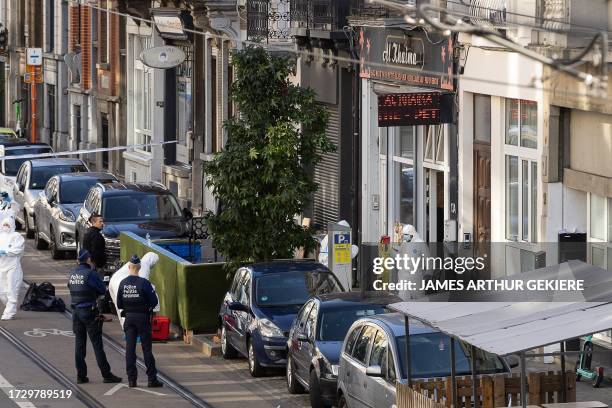 Belgian police officers from the forensic service gather in the street outside the cafe Al Khaima in the Schaerbeek area of Brussels on October 17...