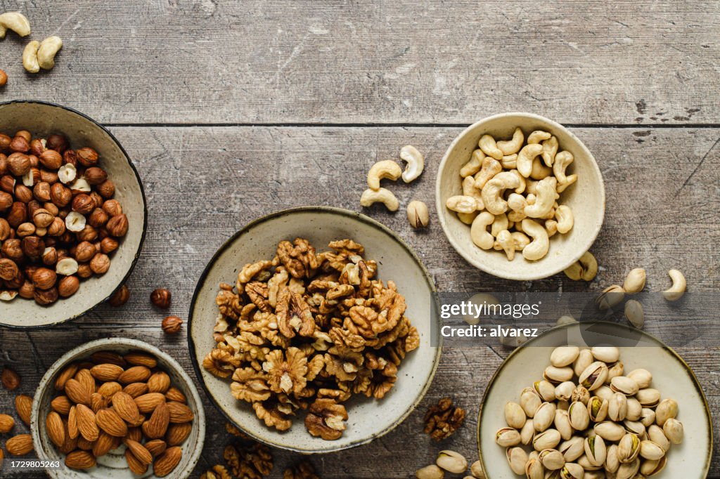 Auswahl an Trockenfrüchten in Schalen auf Holzoberfläche