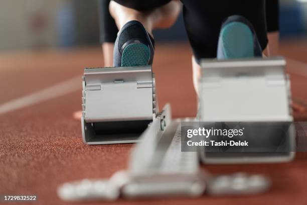 läuferin steht auf dem startblock an der strecke - sprint start stock-fotos und bilder