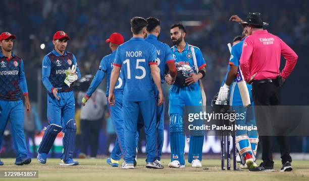 Virat Kohli of India shakes hands with players of Afghanistan following the ICC Men's Cricket World Cup India 2023 between India and Afghanistan at...