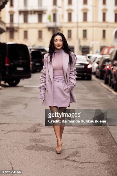Jessica Wang wears lilac gloves, a lilac mini skirt, a lilac coat, and a lilac turtle-neck sweater outside MaxMara during the Milan Fashion Week -...