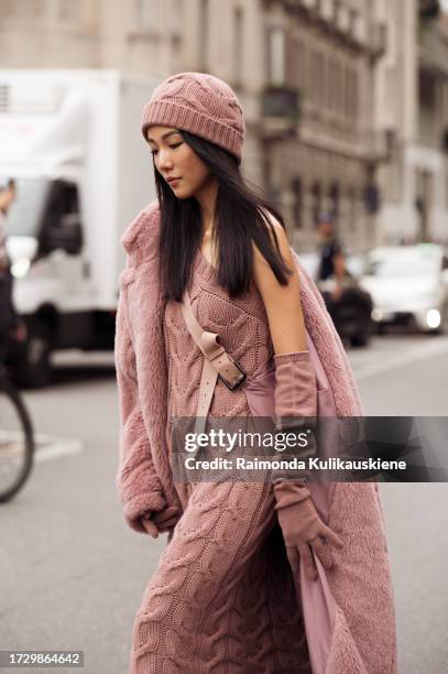 Yoyo Cao wears a pink hat, a matching pink long dress with a cross-body trail, and a pink teddy long coat outside MaxMara during the Milan Fashion...