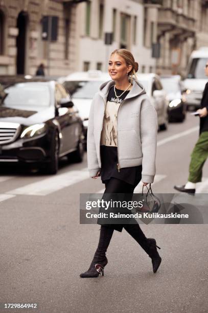 Emili Sindlev is seen wearing Nike silver earrings, a Chanel pearl necklace, a grey oversized Miu Miu hoodie, a Max Mara oversized printed t-shirt, a...