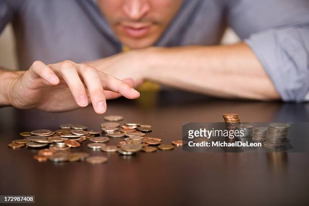 counting or sorting coins, with 4 piles of different types - counting stockfoto's en -beelden
