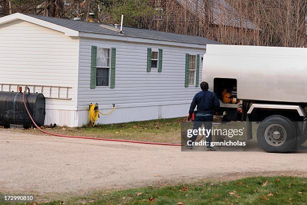 man delivering fuel to countryside home - heating home stock pictures, royalty-free photos & images