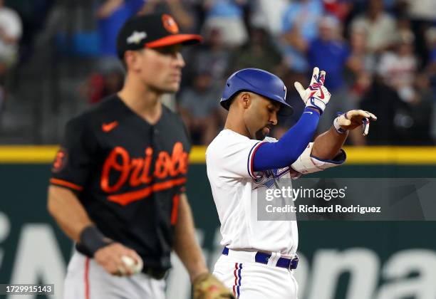 Marcus Semien of the Texas Rangers gestures to the dugout after hitting a double against the Baltimore Orioles in the second inning during Game Three...