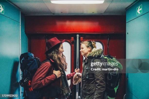 lesbian couple enjoying a trip with train - journey stock pictures, royalty-free photos & images