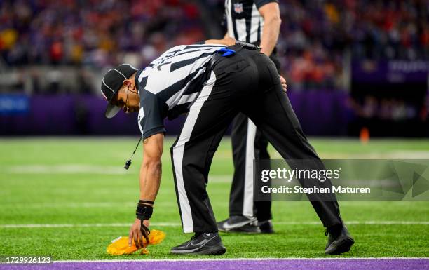 Side judge Dominique Pender picks up a flag after a review in the fourth quarter of the game between the Kansas City Chiefs and Minnesota Vikings at...