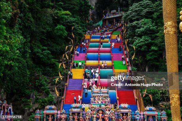 people climbing the colorful stairs to the batu caves in malaysia. - thaipusam stock pictures, royalty-free photos & images