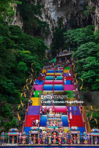 people climbing the colorful stairs to the batu caves in malaysia. - thaipusam stock pictures, royalty-free photos & images
