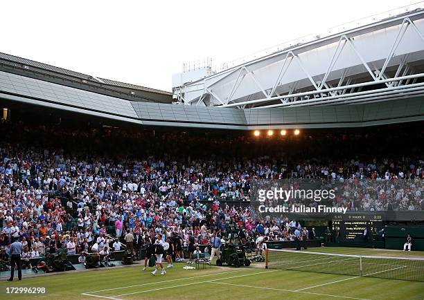 Andy Murray of Great Britain, Jerzy Janowicz of Poland and Chair Umpire Jake Garner walk off Centre Court after Championships' referee Andrew Jarrett...