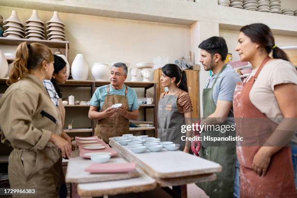 group of people in a pottery class - potter stock pictures, royalty-free photos & images