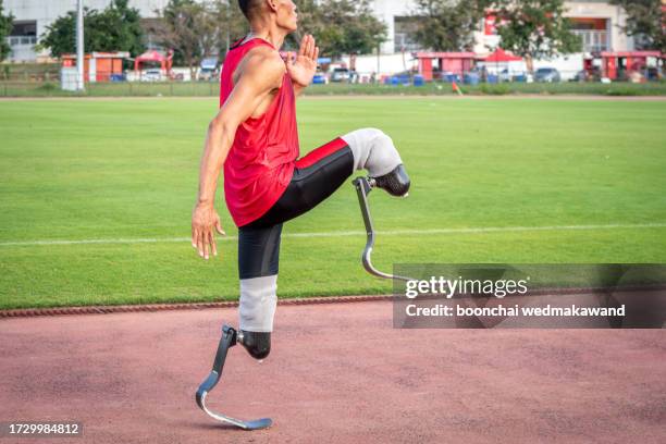 explosive start of athlete with handicap at the stadium - one-armed-person-handicapped-person stock pictures, royalty-free photos & images