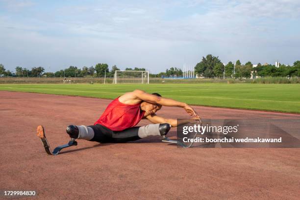 explosive start of athlete with handicap at the stadium - one-armed-person-handicapped-person stock pictures, royalty-free photos & images