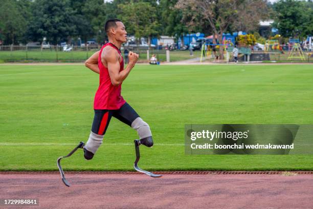 explosive start of athlete with handicap at the stadium - one-armed-person-handicapped-person stock pictures, royalty-free photos & images