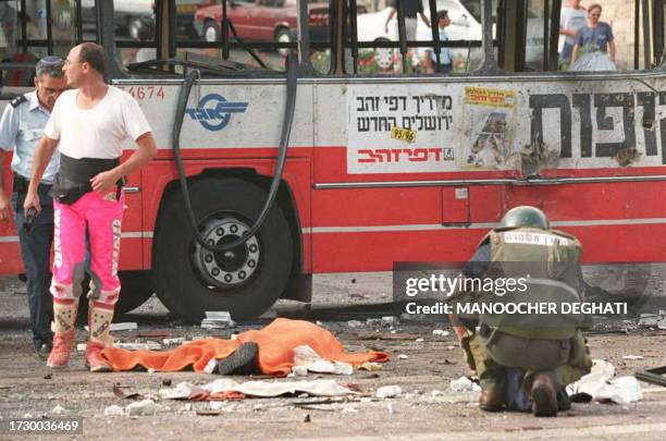 Covered corpse lays at the scene of an explosion where a suspected Moslem suicide bomber blew himself up aboard a rush-hour bus in Jerusalem 21...