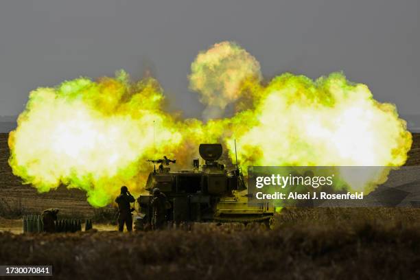 An IDF Artillery solider covers his ears as a shell is fired towards Gaza on October 11, 2023 near Netivot, Israel. Israel has sealed off Gaza and...