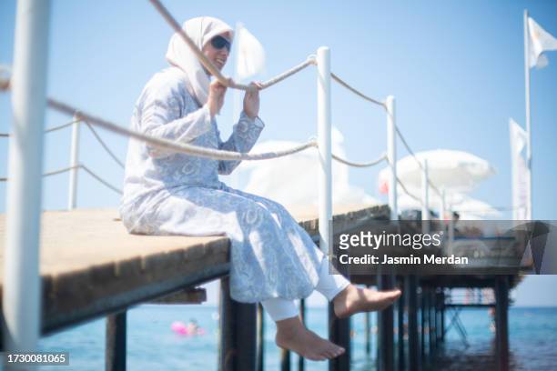 muslim woman enjoying on beach pier - hijab feet stock pictures, royalty-free photos & images