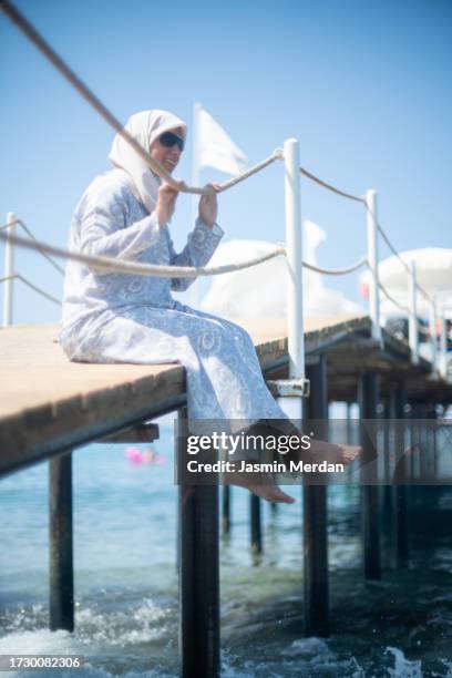 muslim woman enjoying on beach pier - hijab feet stock pictures, royalty-free photos & images