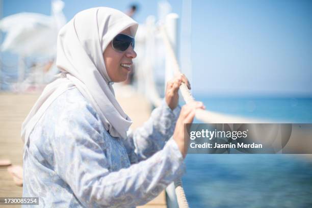 muslim woman enjoying on beach pier - hijab feet stock pictures, royalty-free photos & images