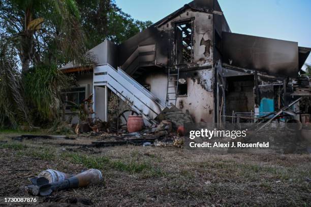 Rocket shells are left on the grass outside a house where civilians and soldiers were killed by Hamas militants days earlier on October 11, 2023 in...