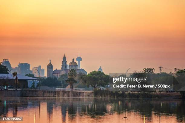 scenic view of lake by buildings against sky during sunset,san antonio,texas,united states,usa - san antonio texas stock pictures, royalty-free photos & images