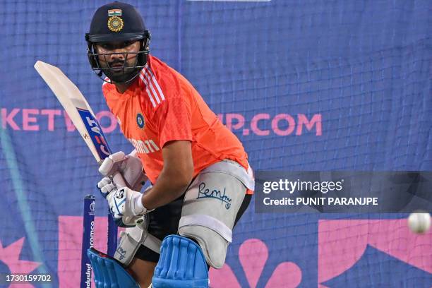 India's captain Rohit Sharma eyes the ball during a practice session ahead of the 2023 ICC Men's Cricket World Cup one-day international match...