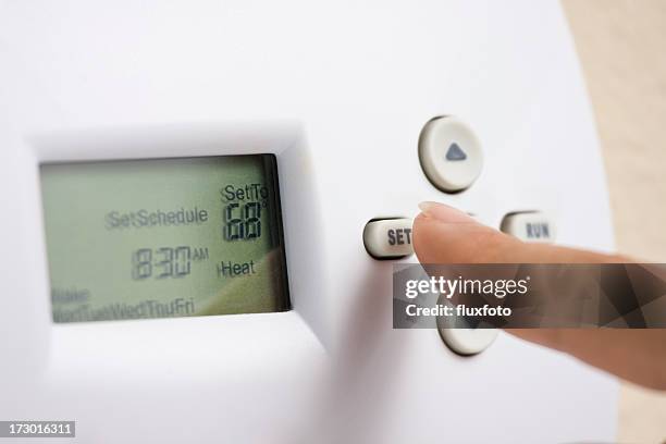 setting electronic thermostat heat to 68 degrees - fahrenheit stock pictures, royalty-free photos & images