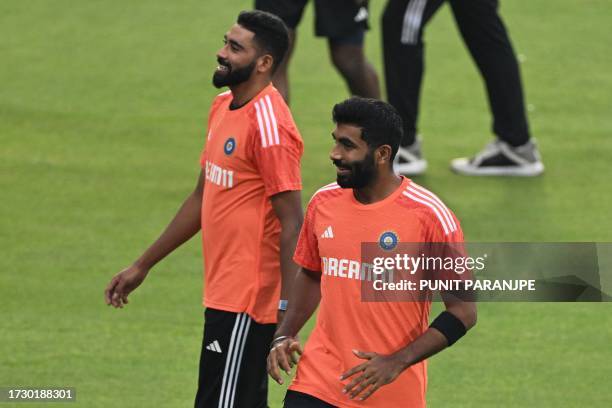 India's Mohammed Siraj and Jasprit Bumrah speak during a practice session ahead of the 2023 ICC Men's Cricket World Cup one-day international match...