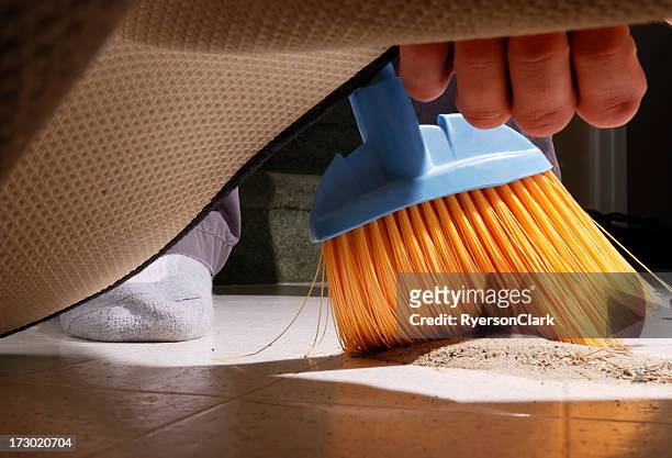 sweeping dirt under the carpet. - sweeping dirt stock pictures, royalty-free photos & images