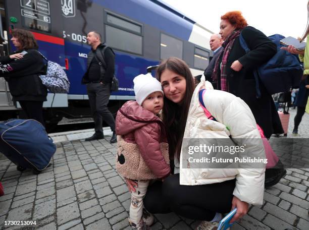 Woman and girl transfer from a modern diesel train of the Ukrzaliznytsia to a train of the Polish SKPL transport company on the maiden trip along the...