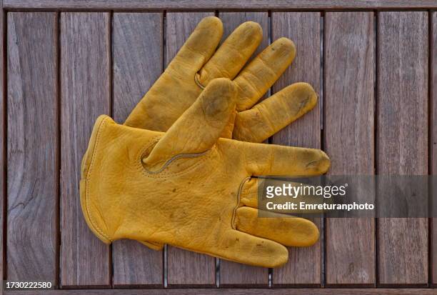 high angle view of work gloves on a table. - leather gloves stock pictures, royalty-free photos & images