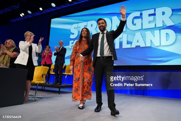Leader of the SNP, Humza Yousaf waves as he stands with his wife Nadia El-Nakla after he gave a speech on day three of the SNP conference at The...