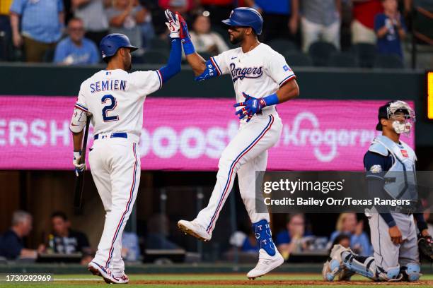 Leody Taveras celebrates with Marcus Semien of the Texas Rangers after hitting a home run during a game against the Tampa Bay Rays at Globe Life...