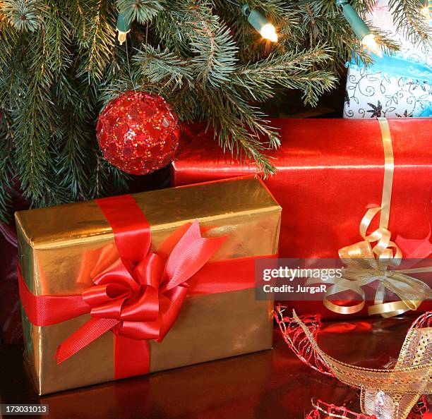 christmas presents with red bow - christmas presents under tree stock pictures, royalty-free photos & images