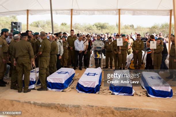 Soldiers carry the coffins during a funeral held for the Kutz family, including parents Aviv and Livnat and children Yonatan, Rotem, and Yiftach, all...