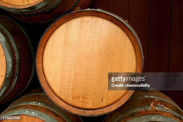 brand new wine barrel sitting on top of other barrels - barrel stockfoto's en -beelden