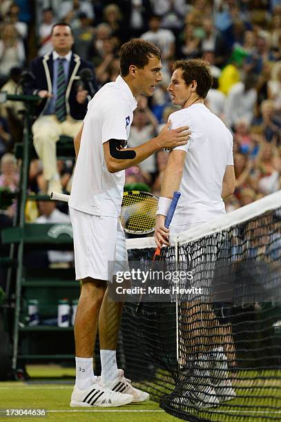 Andy Murray of Great Britain speaks with Jerzy Janowicz of Poland at the net after their Gentlemen's Singles semi-final match on day eleven of the...