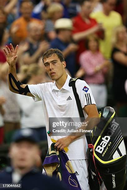 Jerzy Janowicz of Poland waves to the crowd as he walks off Centre Court following his defeat to Andy Murray of Great Britain in the Gentlemen's...