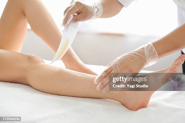 woman receiving a brazilian wax hair removal - waxing hair removal fotografías e imágenes de stock